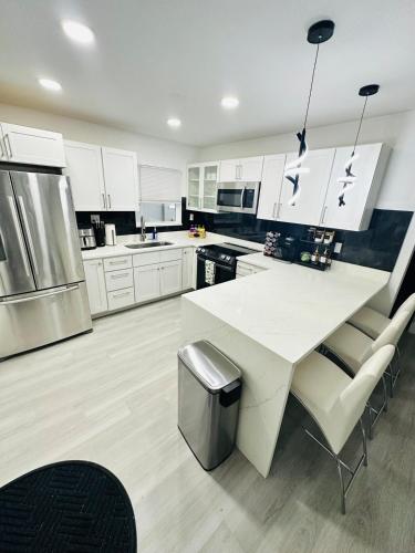 a kitchen with white cabinets and a white table and chairs at Cozy Retreat Near Downtown Fort Myers in Fort Myers