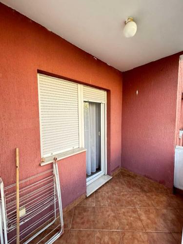 a room with an orange wall with a window at Milenijum in Podgorica