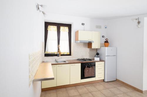a kitchen with white cabinets and a white refrigerator at Case vacanza e camere in Villa Isabella con parcheggio custodito e wifi in Gioia del Colle