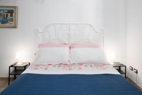 a bedroom with a bed with a white and blue bedspread at Case vacanza e camere in Villa Isabella con parcheggio custodito e wifi in Gioia del Colle