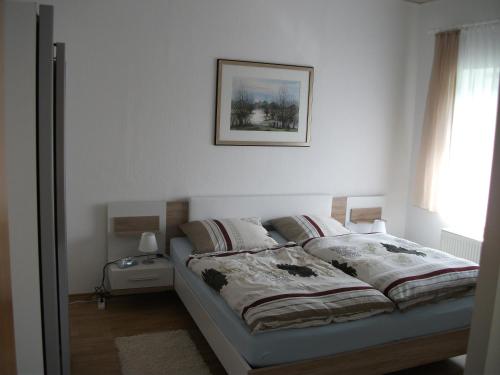 um quarto com uma cama com uma fotografia na parede em Ferienwohnung Am Bach em Rees