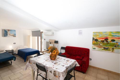 a living room with a red couch and a table at Case vacanza e camere in Villa Isabella con parcheggio custodito e wifi in Gioia del Colle