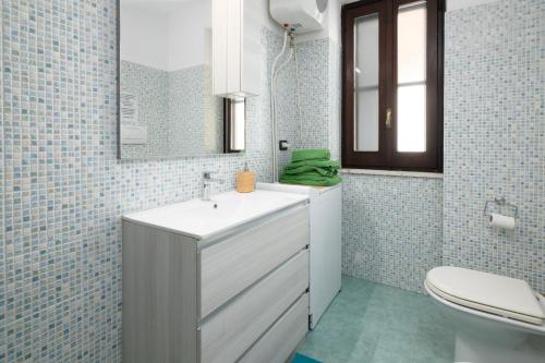 a bathroom with a sink and a toilet and a mirror at Case vacanza e camere in Villa Isabella con parcheggio custodito e wifi in Gioia del Colle