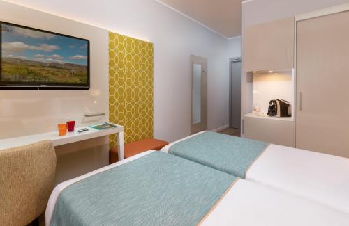 a hotel room with a bed and a television at Leonardo Hotel Verona in Verona