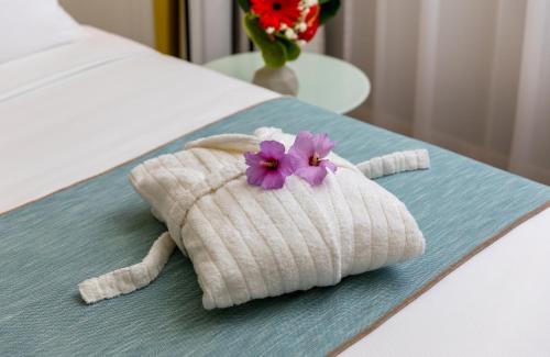 a towel shaped like a dog with purple flowers on a bed at Leonardo Hotel Verona in Verona