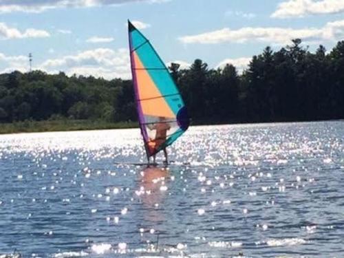 a person is windsurfing on a body of water at CanaanLand in Littleton