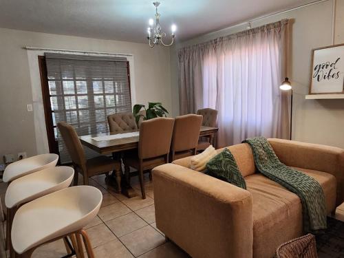 a living room with a couch and a table and chairs at Pearl palace in Polokwane