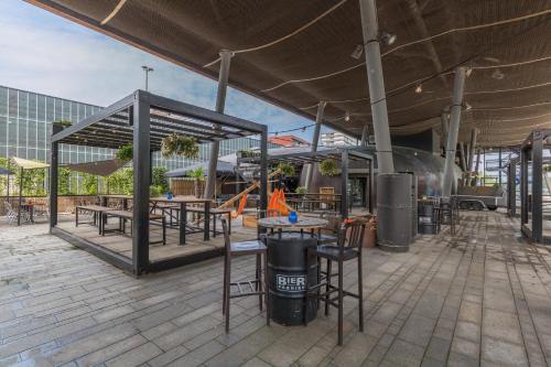 a patio with tables and chairs in a building at Leonardo Hotel Almere City Center in Almere