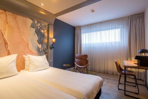 a hotel room with a bed and a desk at Leonardo Hotel Almere City Center in Almere