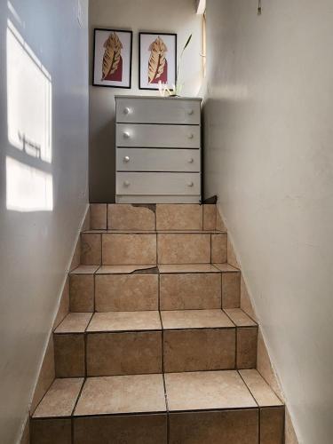 a staircase with a dresser and two pictures on the wall at Pearl palace in Polokwane