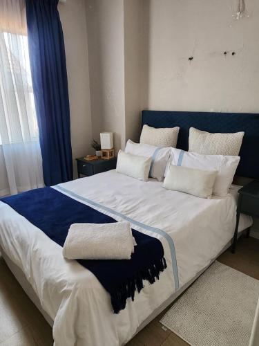 a large bed with blue and white pillows on it at Pearl palace in Polokwane