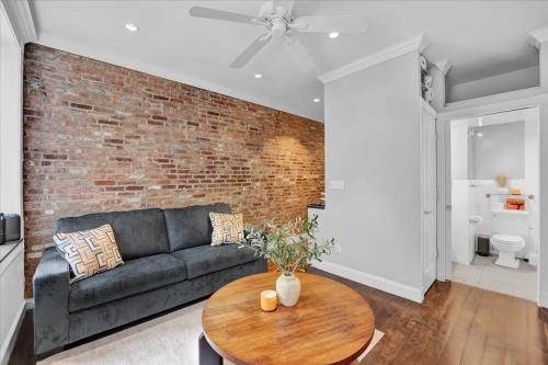 a living room with a couch and a brick wall at Gramercy Apartment - 3BR 2BA Modern Central in New York