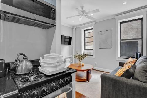 a kitchen and living room with a stove and a couch at Gramercy Apartment - 3BR 2BA Modern Central in New York