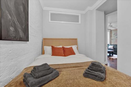 a bedroom with a bed with two towels on it at Gramercy Apartment - 3BR 2BA Modern Central in New York