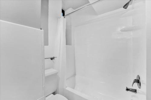a white bathroom with a shower and a toilet at Gramercy Apartment - 3BR 2BA Modern Central in New York