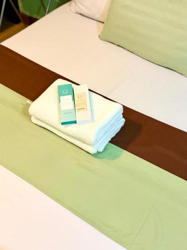 a couple of towels sitting on top of two beds at Albergo Hotel - Studio Condo Unit - Baguio Transient in Baguio