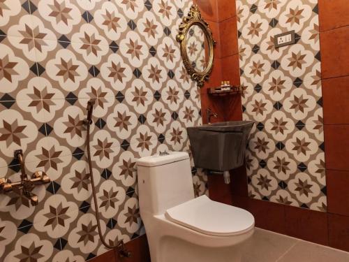 a bathroom with a toilet and a flowery wallpaper at Chola Heritage Resort in Kāraikkudi