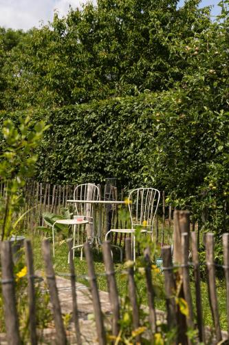 two tables and chairs in front of a fence at B&B Maas en Heuvel Maastricht in Maastricht