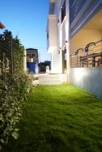 a green yard next to a building at Azur Infini suites and apartments in Olympiada