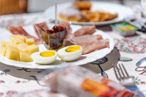 a plate of food with eggs and cheese on a table at Agriturismo Alle Riserve Cavagrande in Avola