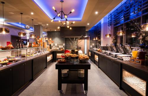 a restaurant with a buffet of food on display at Leonardo Hotel Eschborn Frankfurt in Eschborn