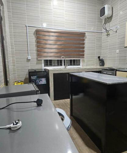 a kitchen with a counter top and a sink at Woodlake Apartment in Dushekoro