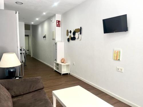 ムルシアにあるApartment next to Hospital Morales Meseguerのソファと壁掛けテレビのあるリビングルーム