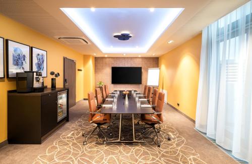 a conference room with a long table and chairs at Leonardo Hotel Eschborn Frankfurt in Eschborn