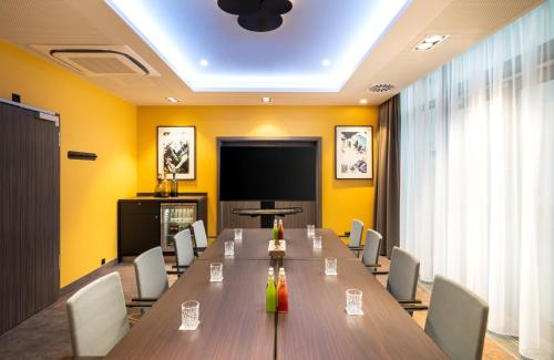 a conference room with a long table and chairs at Leonardo Hotel Eschborn Frankfurt in Eschborn