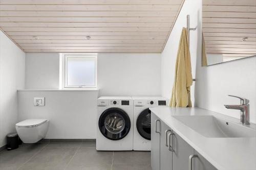 a white laundry room with a washer and a sink at 6838-Allinge-Stakkebakken-9 in Allinge