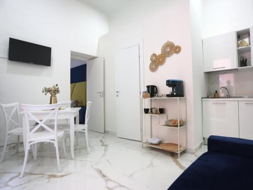 Una sala de estar con mesa y sillas y una cocina. en RODA Apartments, en Nápoles