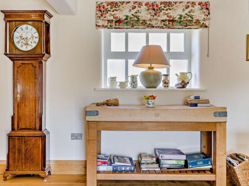 a table with a grandfather clock next to a window at 2 Bed in Wincle PK928 in Allgreave
