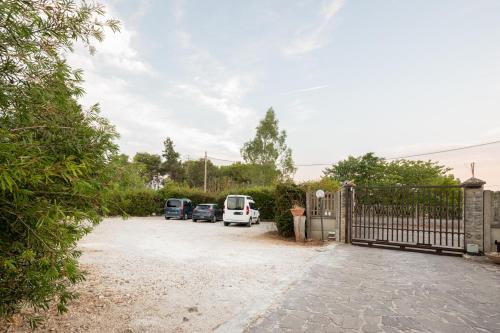 a driveway with cars parked next to a fence at Case vacanza e camere in Villa Isabella con parcheggio custodito e wifi in Gioia del Colle