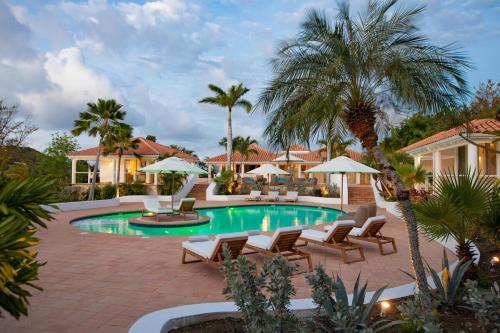 泰尔斯贝斯Villa Sun Reset - 6 bedrooms villa Sunrise & sunset view的房子旁边有带椅子和遮阳伞的游泳池