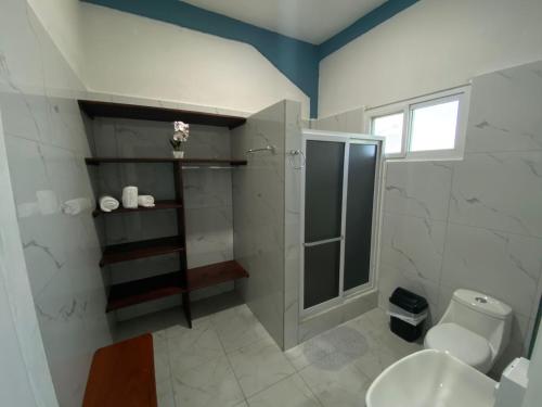 a bathroom with a shower and a toilet and a sink at Habitaciones Cahui in El Remate
