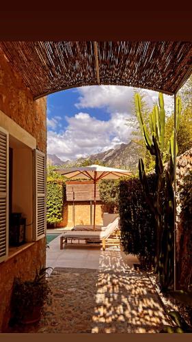 a patio with a bench and an umbrella at Luxurious finca with pool, Soller - Mallorca in Sóller