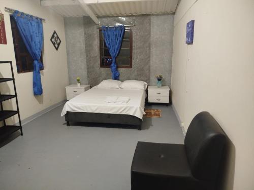 a bedroom with a bed and a chair in it at Eco-hostal Namaste in Salento