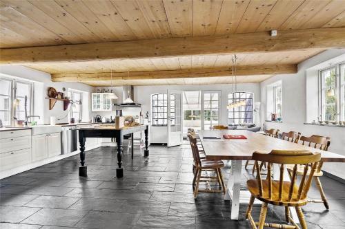 a kitchen with a wooden ceiling and a table and chairs at 4731-Aakirkeby-Dalegardsvej-13 in Åkirkeby