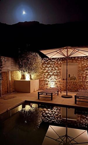 a patio with a table and an umbrella and a pool at Luxurious finca with pool, Soller - Mallorca in Sóller