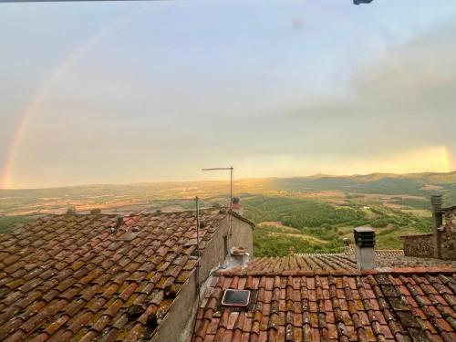 a group of roofs with a rainbow in the background at Casa Betta - A 700 Year Old Tuscan Gem in Chiusdino