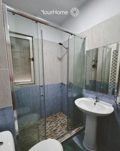 a bathroom with a shower and a sink at Your Home Tirana in Shkozë