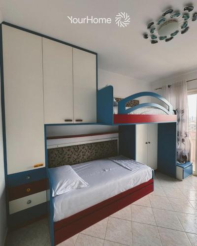 a bedroom with a blue bunk bed with white cabinets at Your Home Tirana in Shkozë