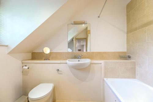 ein Badezimmer mit Waschbecken, Toilette und Spiegel in der Unterkunft Dale Cottage in East Rudham