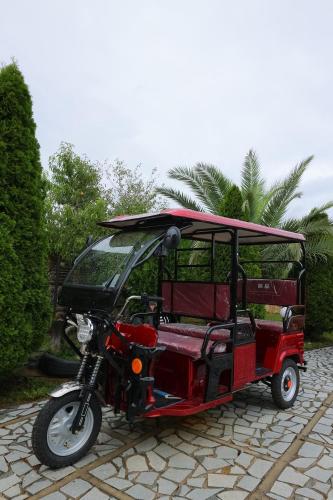a red golf cart parked on a cobblestone street at Hotel Harmony Premium in Kutaisi