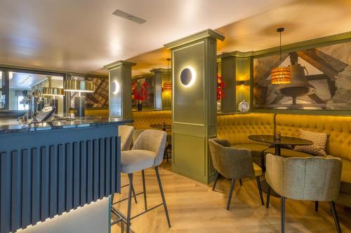 a restaurant with a bar with chairs and tables at Leonardo Hotel Antwerp The Plaza in Antwerp