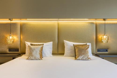 two beds with pillows in a hotel room at Leonardo Hotel Antwerp The Plaza in Antwerp