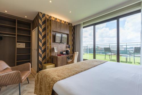 a bedroom with a large bed and a large window at Leonardo Hotel Antwerp The Plaza in Antwerp