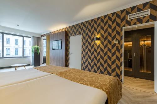 a bedroom with a large bed in a room at Leonardo Hotel Antwerp The Plaza in Antwerp