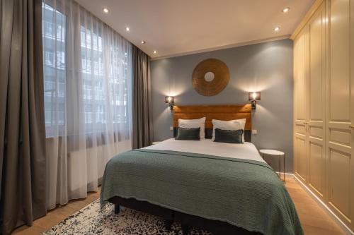 a bedroom with a bed and a large window at Leonardo Hotel Antwerp The Plaza in Antwerp