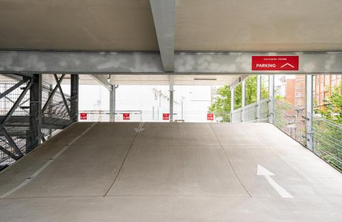 an empty parking lot with a sign in a building at Leonardo Hotel Hamburg Altona in Hamburg